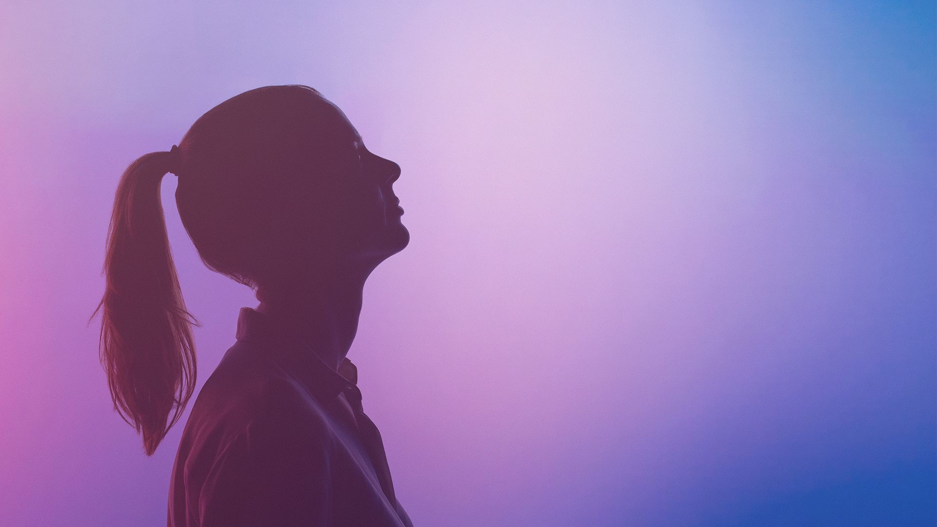 Female side profile silhouette against purple background