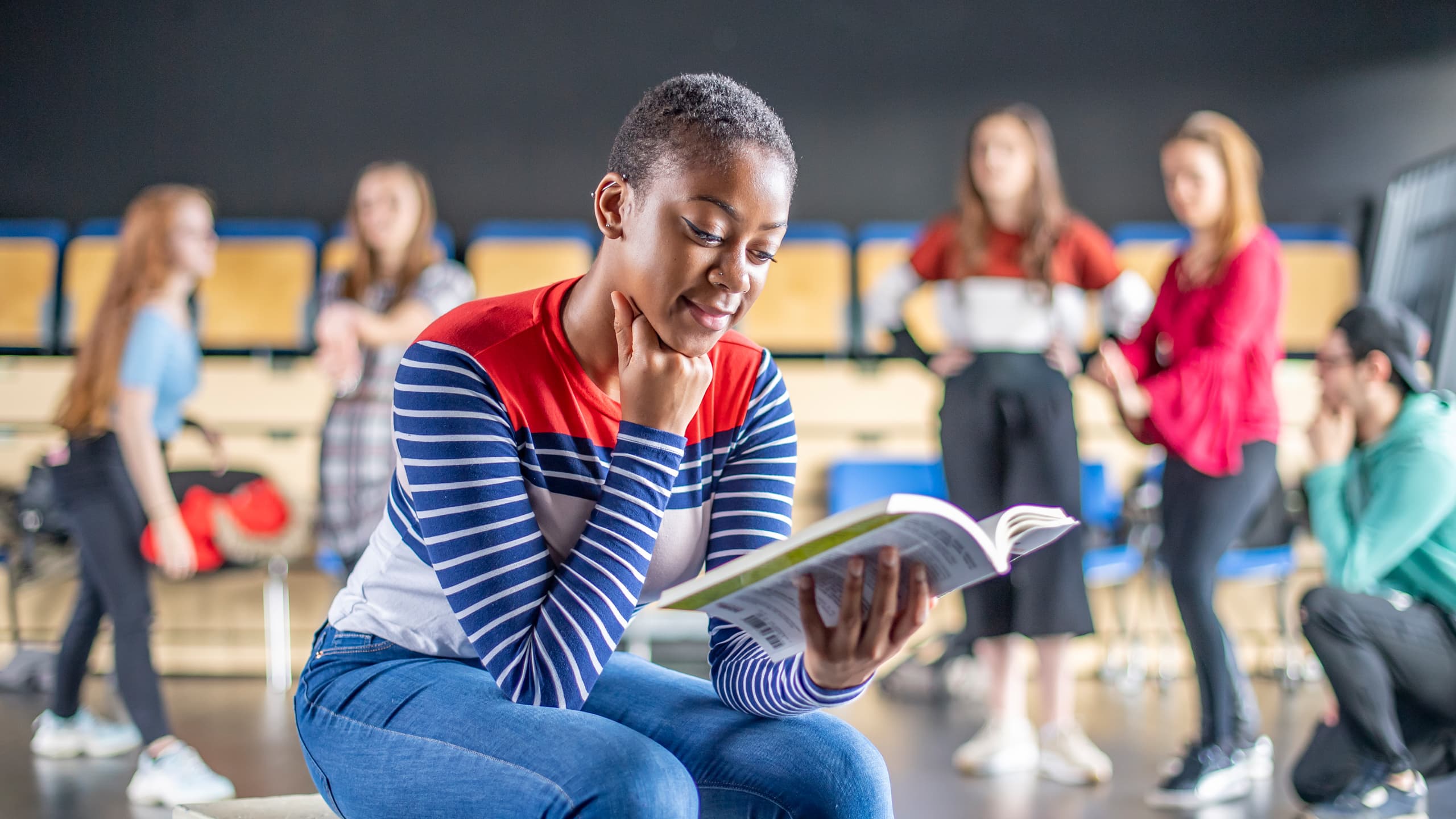 Female student sitting reading literature