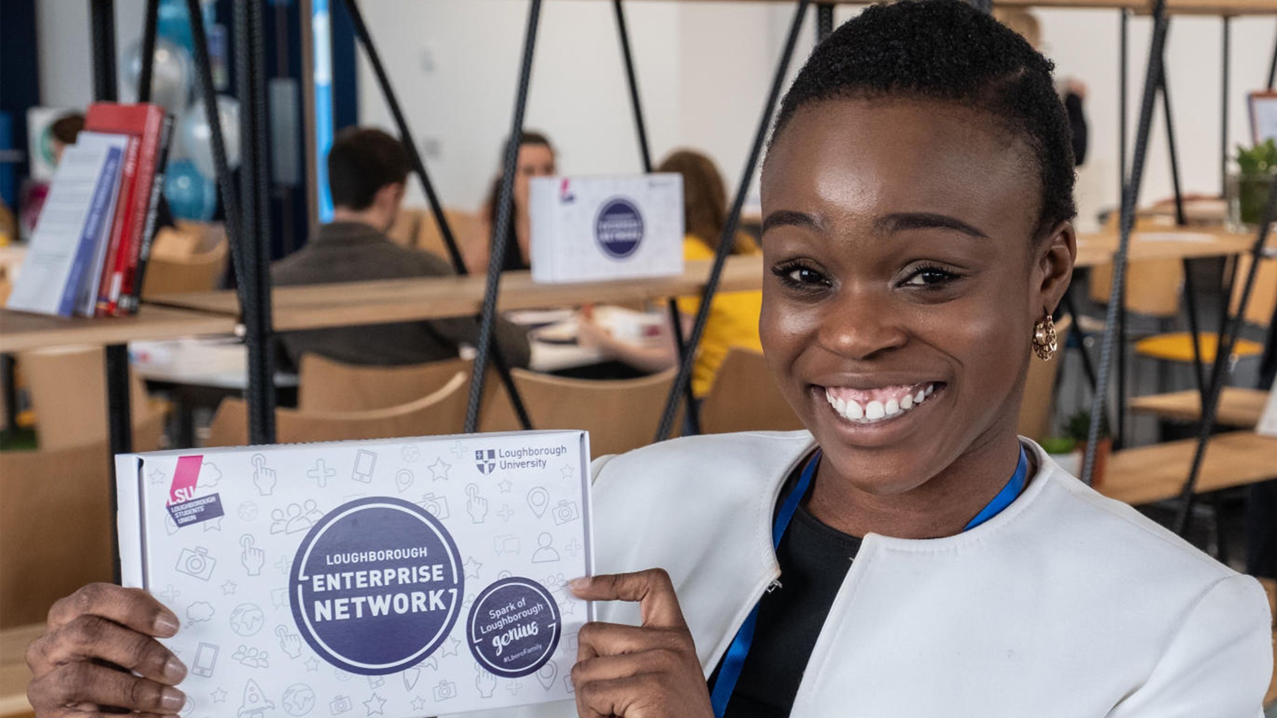 Student holding Loughborough Enterprise Network promotional material