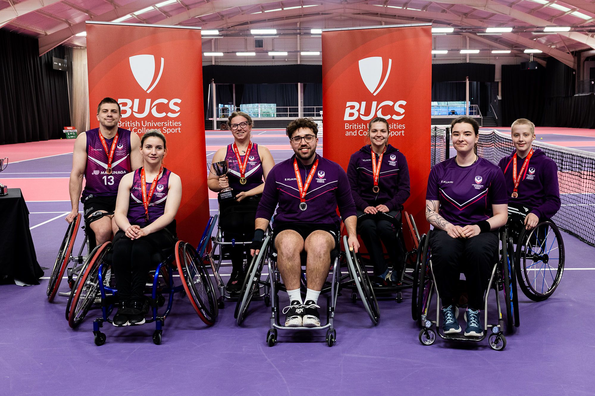 A group of people in wheelchairs wearing medals