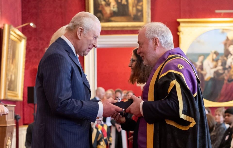 King Charles presents an award to the Vice Chancellor of Loughborough University